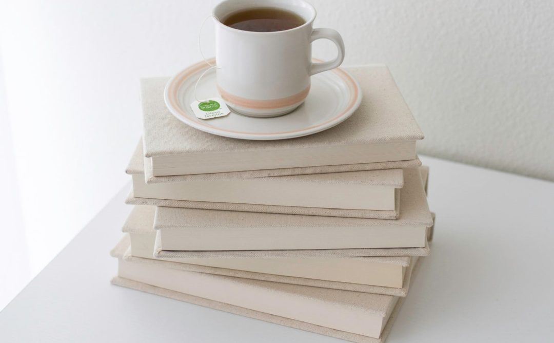 stack of books with coffee cup on top, feature image for summer book reviews