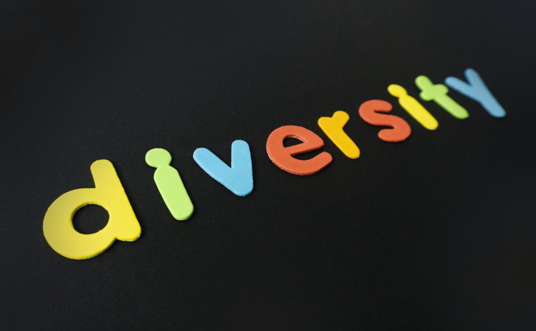 This picture is of the word "diversity" in multi-colored letters against a black background.