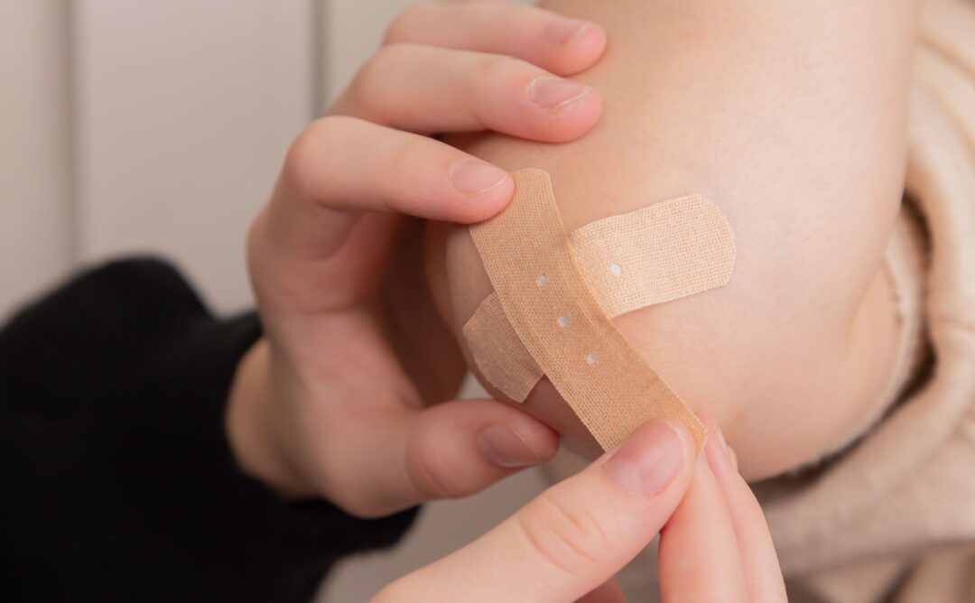 This is a picture of 2 hands applying a second tan bandage to another person's knee. This represents the benefits of failure.