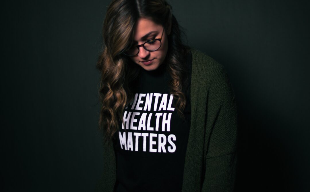 This is a picture of a woman wearing a black shirt that says "Mental Health Matters" in white block letters.