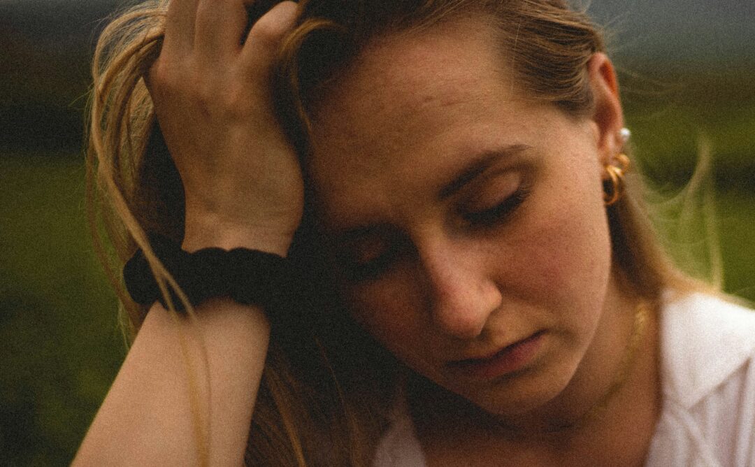 This is a picture of a Caucasian girl with dirty blonde hair. She has her hand on her forehead, and she is looking down. She appears to be sad or tired. I chose her to represent movies about women and mental health.