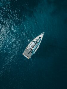 This is a picture of a white boat in the middle of a dark blueish green body of water.